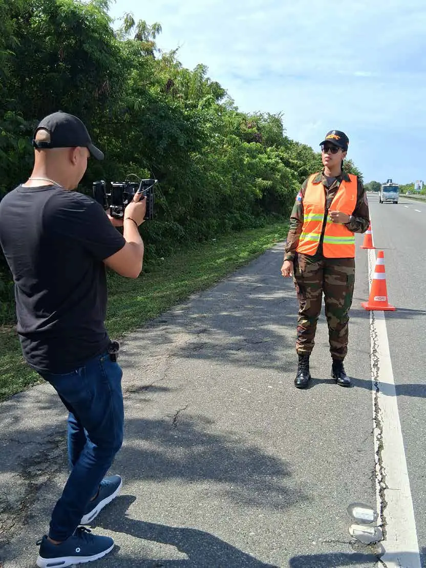 Camarógrafo grabando a una agente en carretera